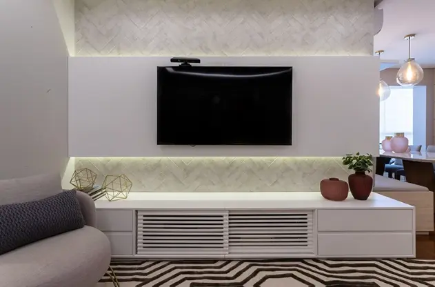 3 Dicas para TV na Parede: Altura Ideal e Decoração 7 Considere os revestimentos e móveis que já existem no espaço para criar um décor harmonioso – Projeto: Mari Milani + Arquitetas | Foto: Rafael Ramos