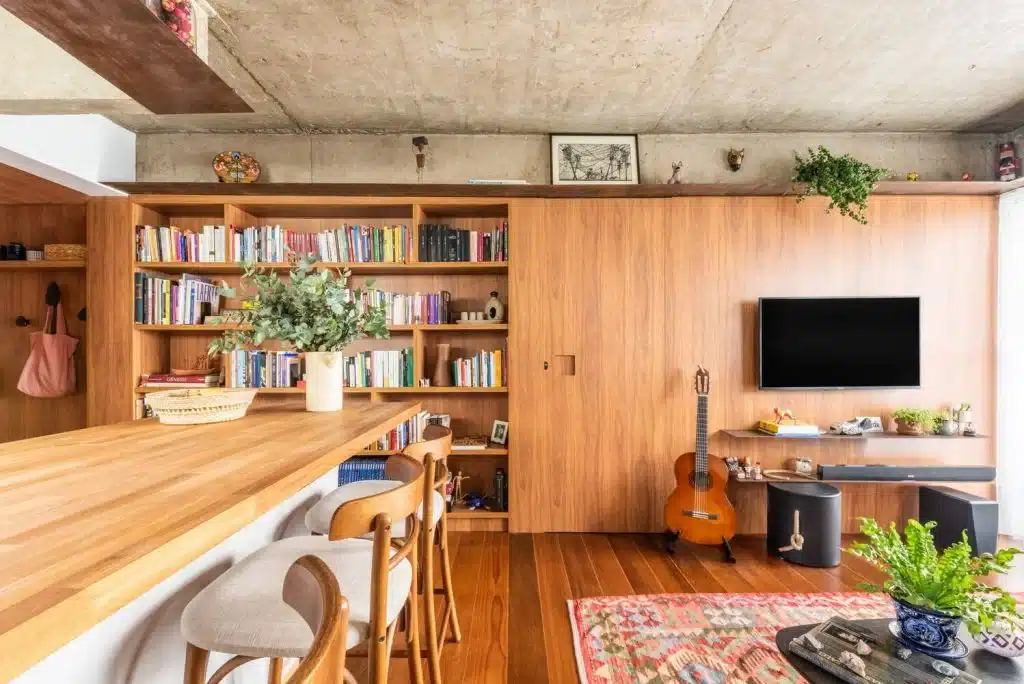 5 Passos para Encontrar o Apartamento Ideal 2 Sala de estar, biblioteca da família e balcão dividem o mesmo ambiente assinado por LCAC Arquitetura
