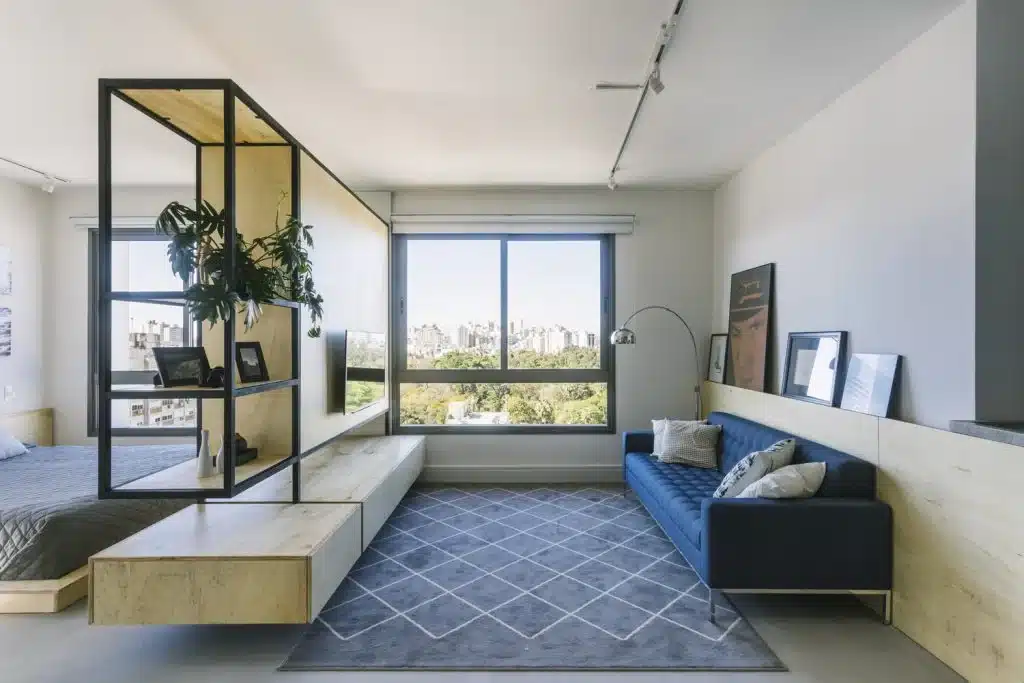 5 Passos para Encontrar o Apartamento Ideal 3 O móvel que abriga a TV também setoriza o ambiente de estar e do quarto, no ambiente projetado por BARRA Arquitetos